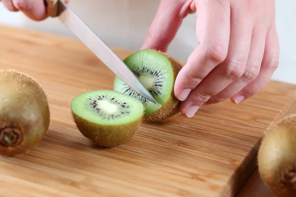 Woman's hands cutting kiwi — Stock Photo, Image