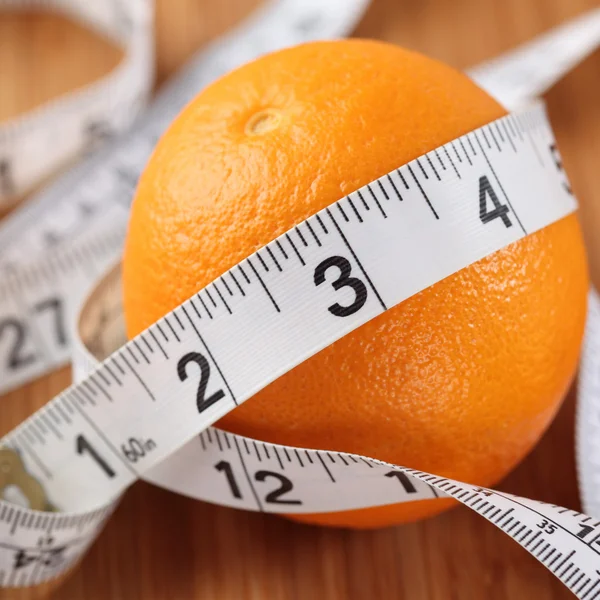 Orange wrapped in a tape measure — Stock Photo, Image