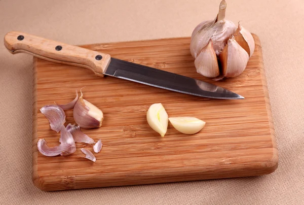 Ajo y cuchillo en tabla de cortar —  Fotos de Stock