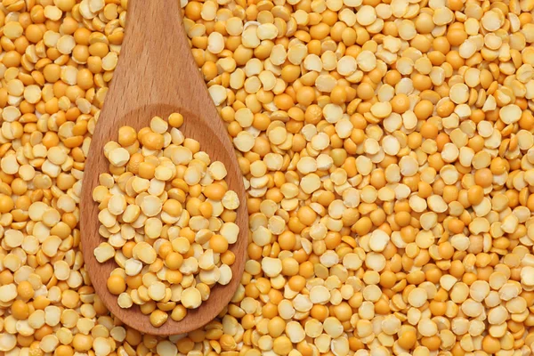 Guisantes amarillos partidos en una cuchara de madera — Foto de Stock