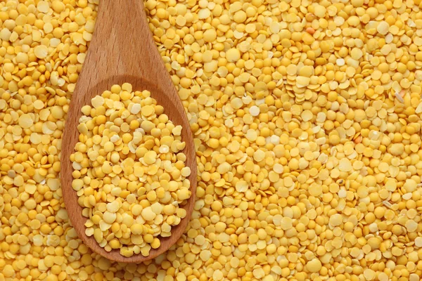 Yellow lentils in a wooden spoon — Stock Photo, Image