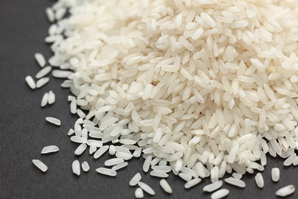 Rice heap på svart bakgrund — Stockfoto
