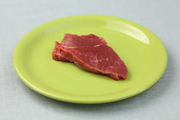 Raw fillet beef steak on a green plate — Stock Photo, Image