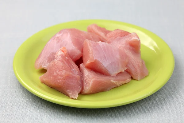 Raw turkey fillet on a green plate — Stock Photo, Image