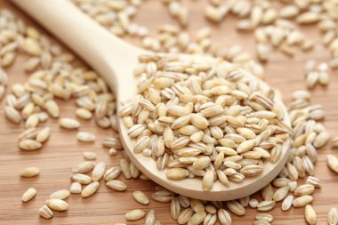 Pearl barley in a wooden spoon clipart