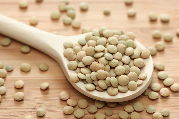 Groene linzen in een houten lepel — Stockfoto