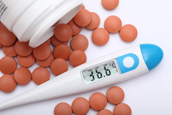 Thermometer and medicine pills — Stock Photo, Image