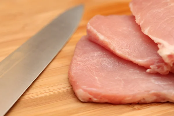 Fresh pork meat and knife on cutting board — Stock Photo, Image