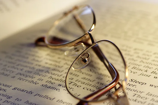 Open book and reading glasses Stock Image