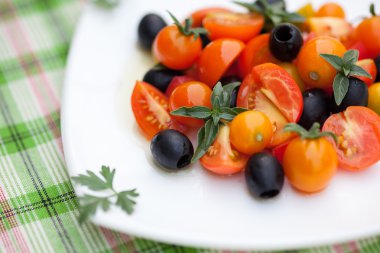 Salata domates, zeytin ve fesleğen bir plaka üzerinde