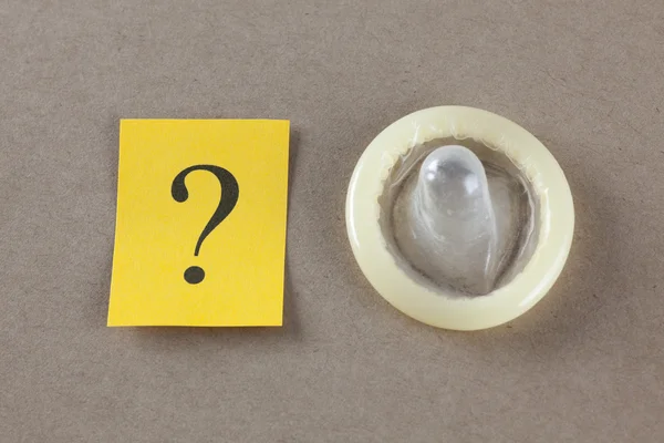 Знак вопроса и презерватив — стоковое фото