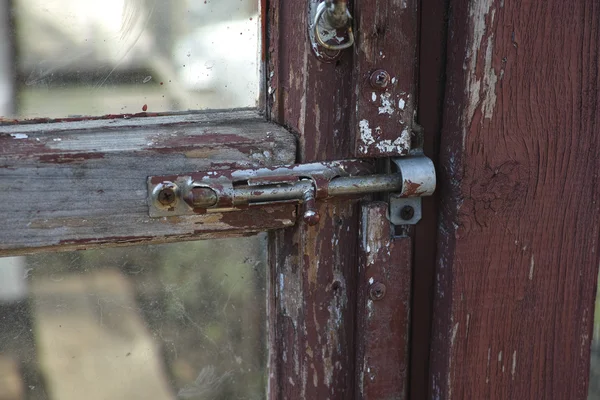 Old latch on the abandoned glass door — Stock Photo, Image