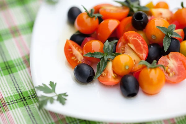 Salada com tomates, azeitonas e manjericão em uma chapa — Fotografia de Stock