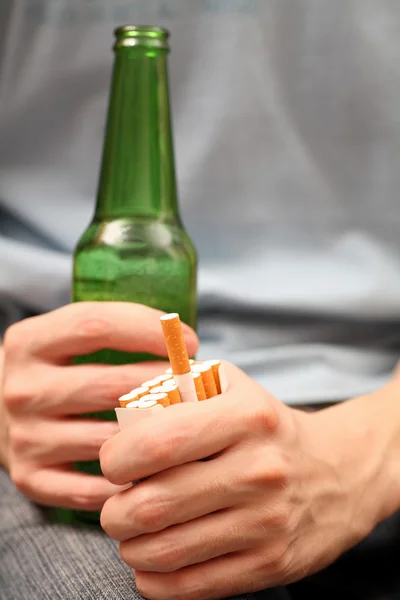 Young man with beer and cigarettes — Stock Photo, Image