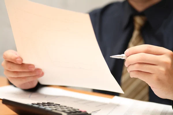 Businessman viewing financial statements — Stock Photo, Image