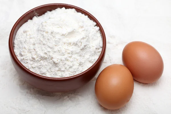 Flour in bowl and two eggs — Stock Photo, Image