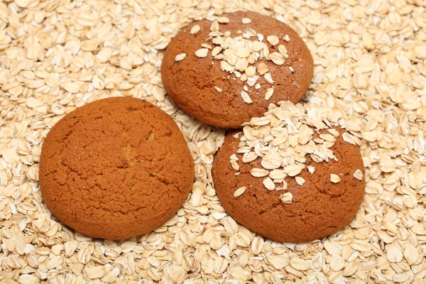 Oatcakes on rolled oats background — Stock Photo, Image