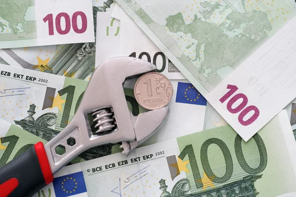 One ruble coin grip in a adjustable wrench on euro banknotes — Stock Photo, Image