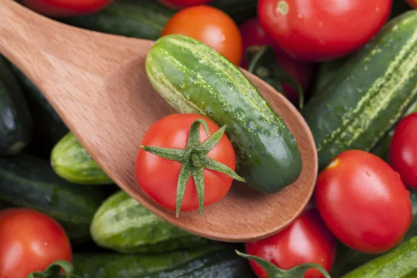 Tomato and cucumber in a wooden spoon — Stock Photo, Image