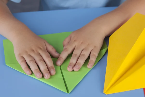 Kind maken van een papieren vliegtuig — Stockfoto
