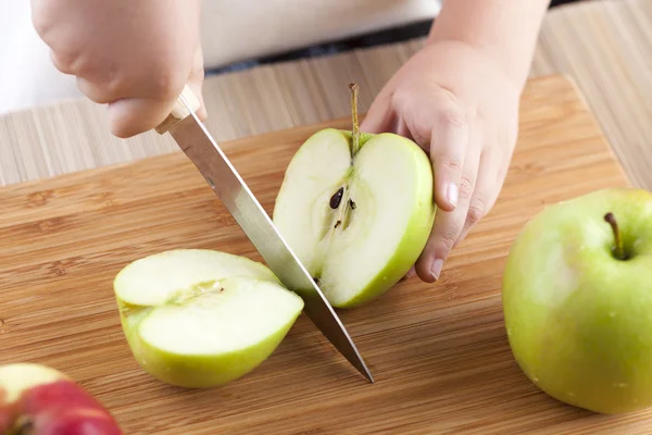 Las manos del niño cortando manzana —  Fotos de Stock