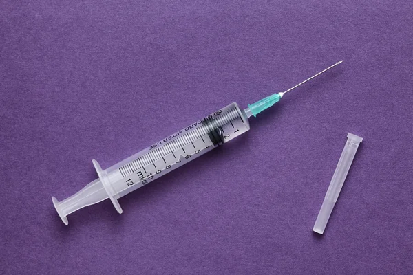 Syringe on a purple background — Stock Photo, Image