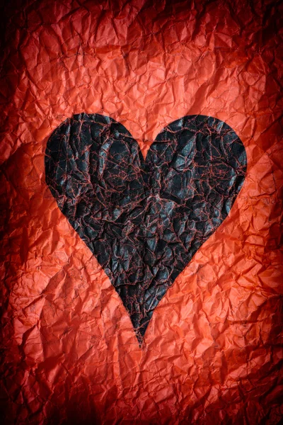 Crumpled red paper with black heart — Stock Photo, Image
