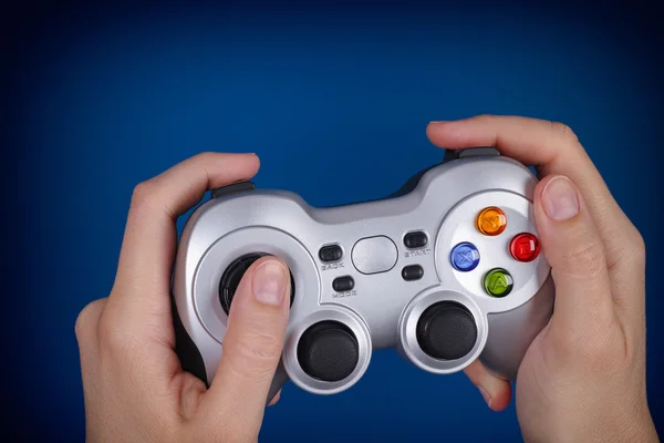 Giovane donna gioca al videogioco utilizzando un gamepad — Foto Stock