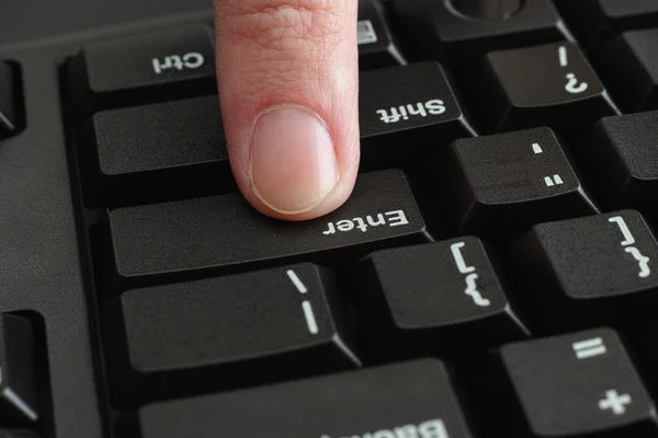 Finger empurrando Enter tecla no teclado preto — Fotografia de Stock