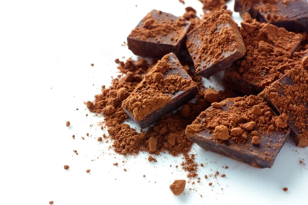 Broken dark chocolate with cocoa powder — Stock Photo, Image