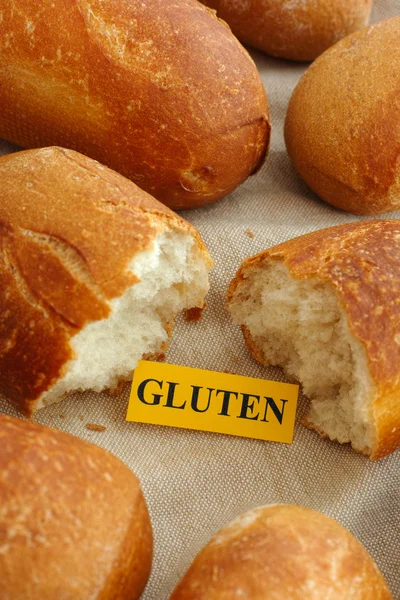 Stuk papier met het woord gluten in een broodje — Stockfoto