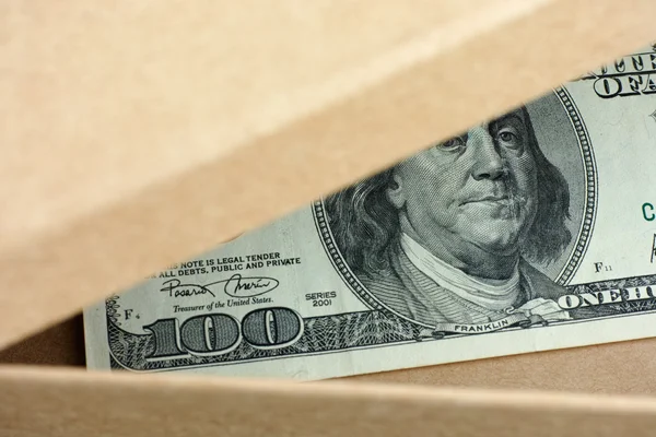 Open box with one hundred dollars banknote in it