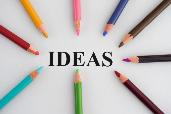 Word ideeën en kleurrijke potloden — Stockfoto