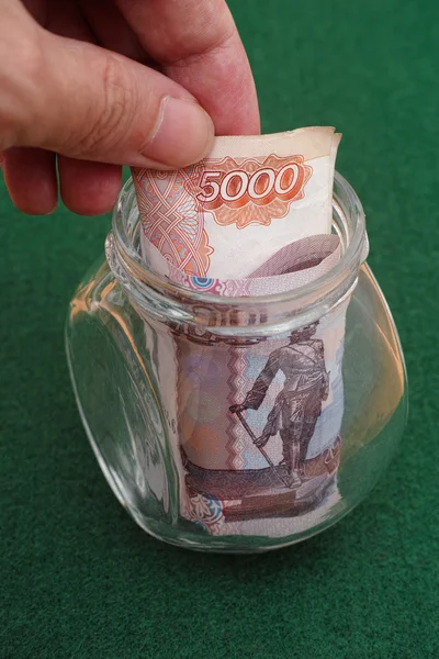 Man taking five thousand ruble notes out of jar — Stock Photo, Image