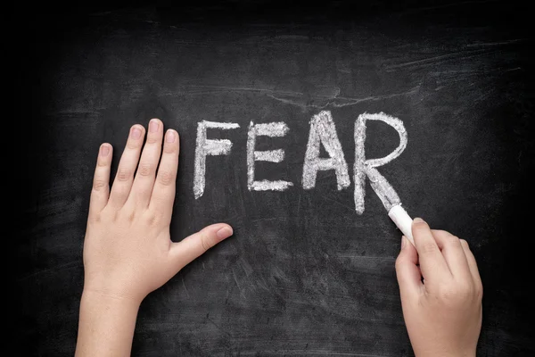 Child writing word Fear on blackboard — Stock Photo, Image