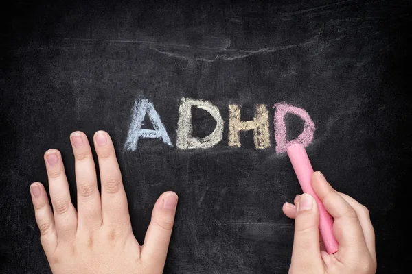 Child writing ADHD on blackboard — Stock Photo, Image