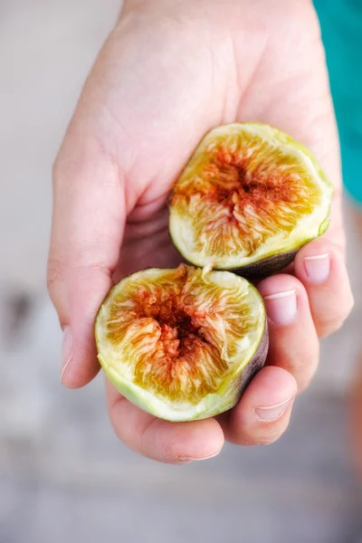 Two halves of fresh fig in woman hand — Stock Photo, Image