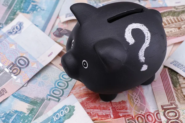 Piggy bank preto com ponto de interrogação e rublos russos — Fotografia de Stock