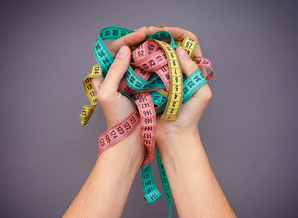 Colorful measuring tapes in woman palms. Diet concept — Stock Photo, Image