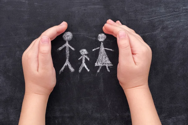 Kind-handen bescherming van familie getrokken op schoolbord — Stockfoto