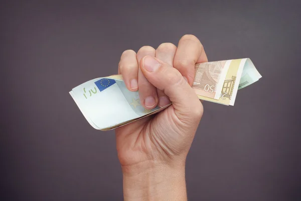 Woman hand squeezes euro banknotes — Stock Photo, Image