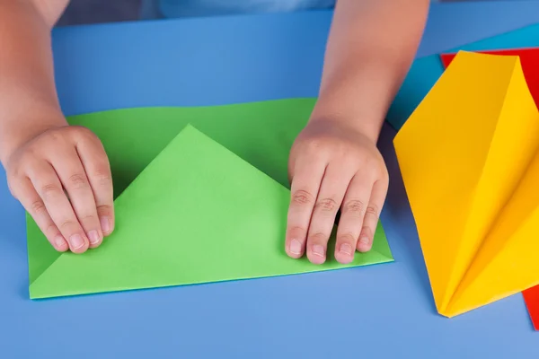 Bambino che fa un piano di carta verde — Foto Stock