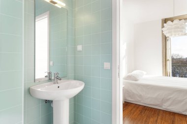 Yatak odasına bakan yeşil kiremitli banyo.