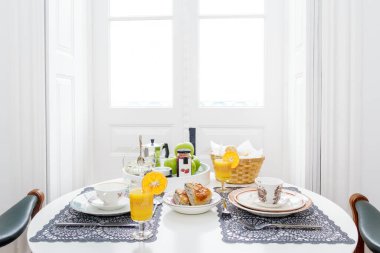 İki kişilik lüks kahvaltı masası portakal suyu, reçel, hamur işi, elma, kahve ve çay.
