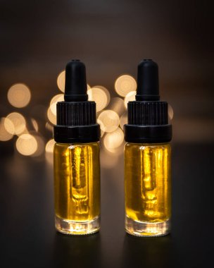 CBD yağı karamsar arka plan üzerine loş ışıklandırma ile düşer