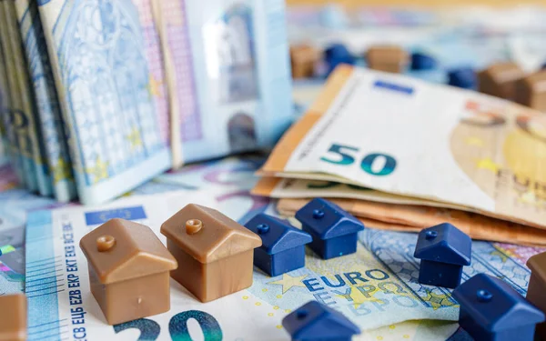 硬貨に囲まれた20ユーロ紙幣と50ユーロ紙幣を背景にした住宅モデル 不動産コンセプト 住宅ローン 住宅ローン 不動産投資 ストック画像
