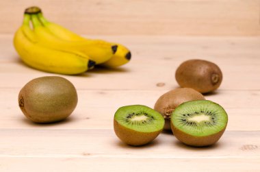 Tahta arka planda tropikal meyve kivisi ve muz. seçici odak