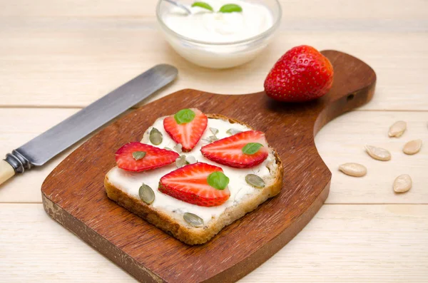 Appetitanregender Toast Mit Frischkäse Und Erdbeeren Und Kürbiskernen Auf Einem — Stockfoto