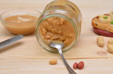 Ters çevrilmiş fıstık ezmesi kavanozu ve kaşık yakın plan.