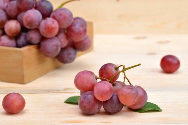 Tahta bir masada pembe üzüm dalı